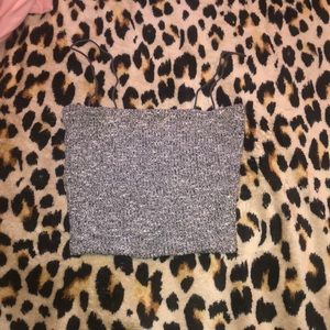 A grey and white spaghetti strapped top .